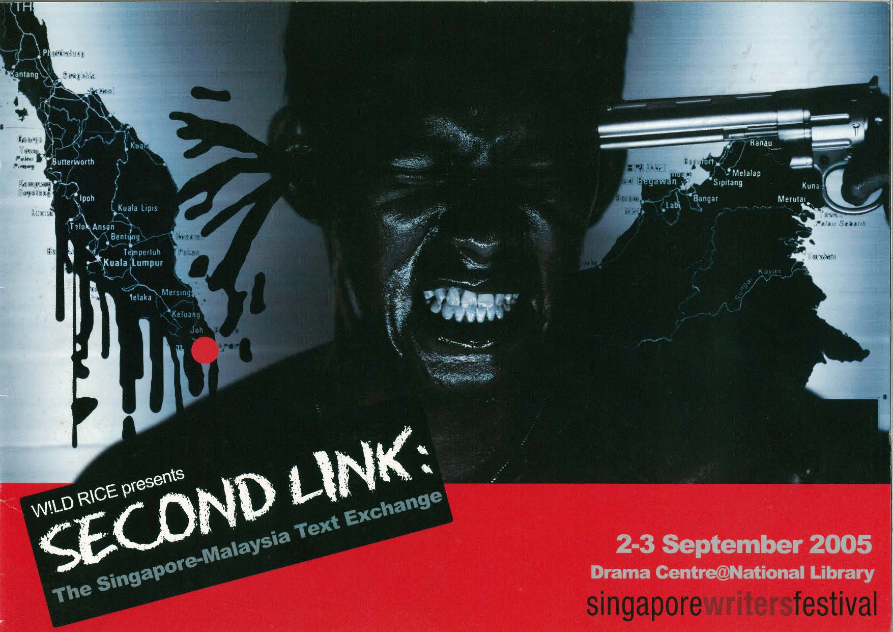 A person covered in black paint, looking pained with their teeth gritted. A gun is held to their head. Behind them are maps of the territories of Malaysia.