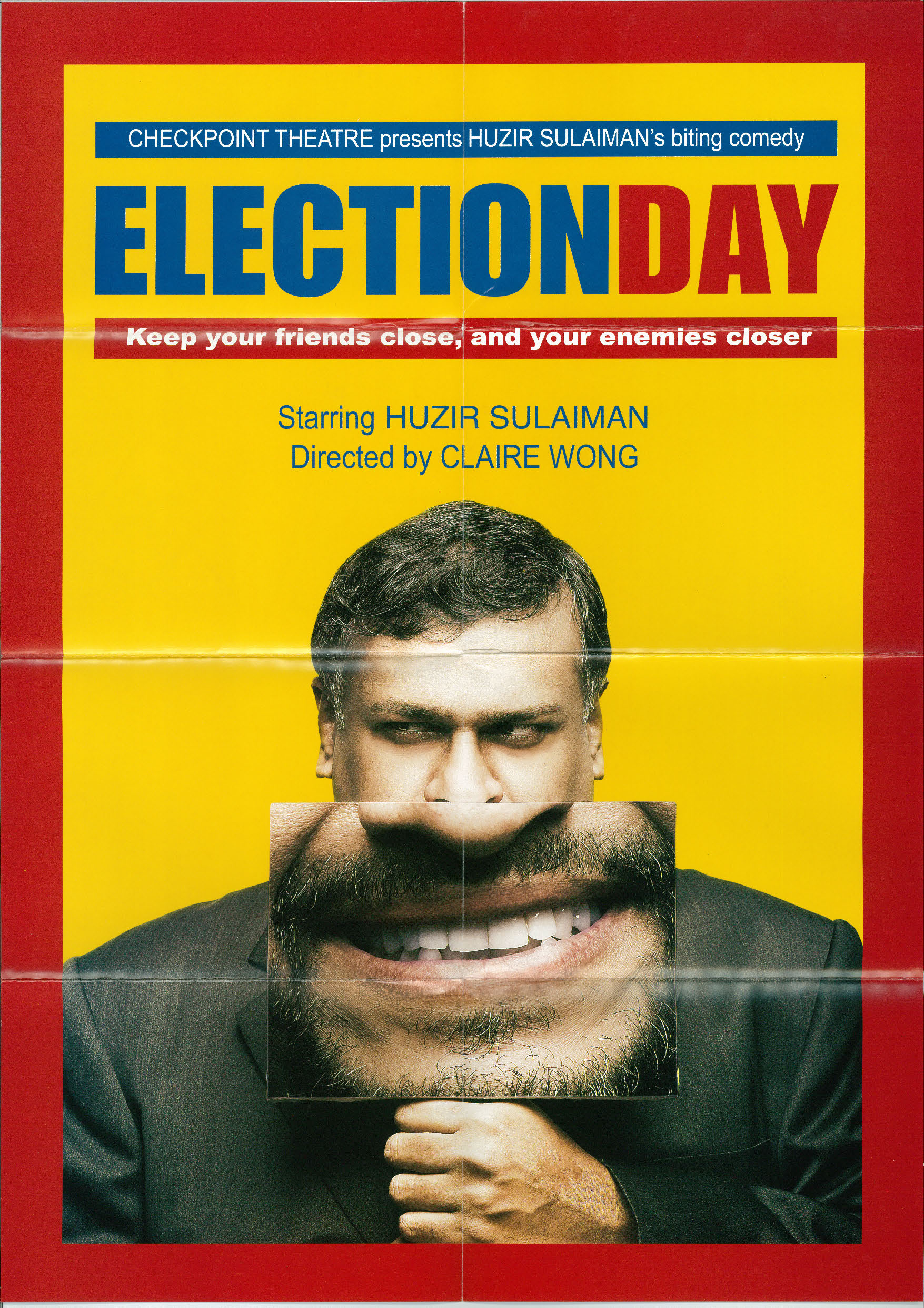 The programme of "Election Day" features a shifty looking man wearing a suit holding a placard with a blown up image of his grin, set against a bright yellow backdrop framed with a thick red box. The title is in bold with the word Election in blue and the word day, and the credits in red.  