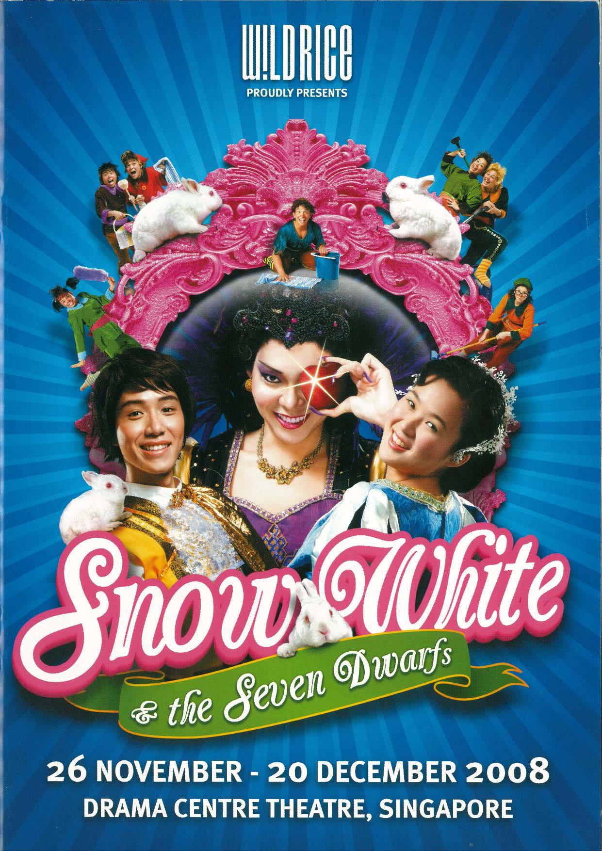 The programme is royal blue with a bright pink mirror in the centre of the page, which frames 3 main figures, a princely figure in a golden coat, a princess in a blue dress and between them is a witch, dressed in a deep purple dress and flamboyant feathery headpiece holding up a gleaming apple to her eye.