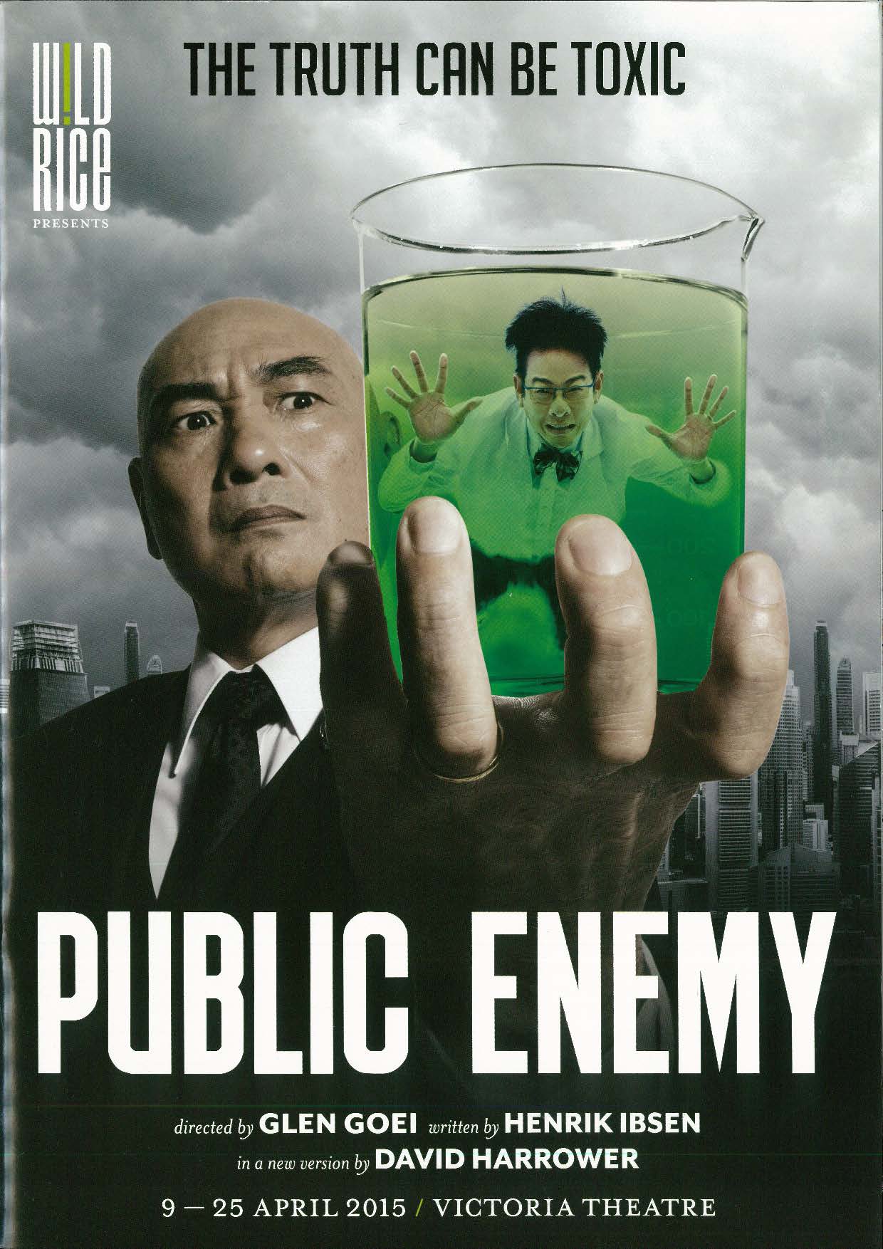 The programme has a background with an image of a grey sky with clouds. On the left, a bald figure dressed in a black suit and tie has a stern expression, and is holding up a glass of green liquid with a bespectacled man in it. The title appears in bolded, white font at the bottom. 