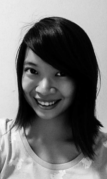 A black and white image of a lady smiling brightly. She is wearing a round collared top. 