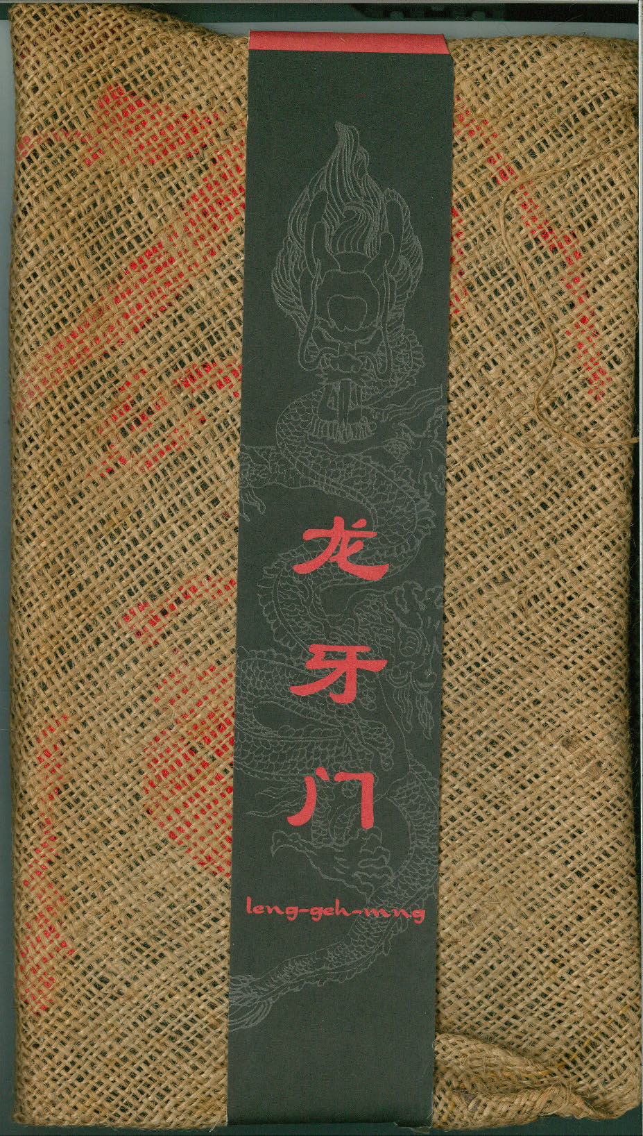 The programme is a woven bag with a strip of paper binding it that features an outline of a Chinese dragon and the title printed in red on it.