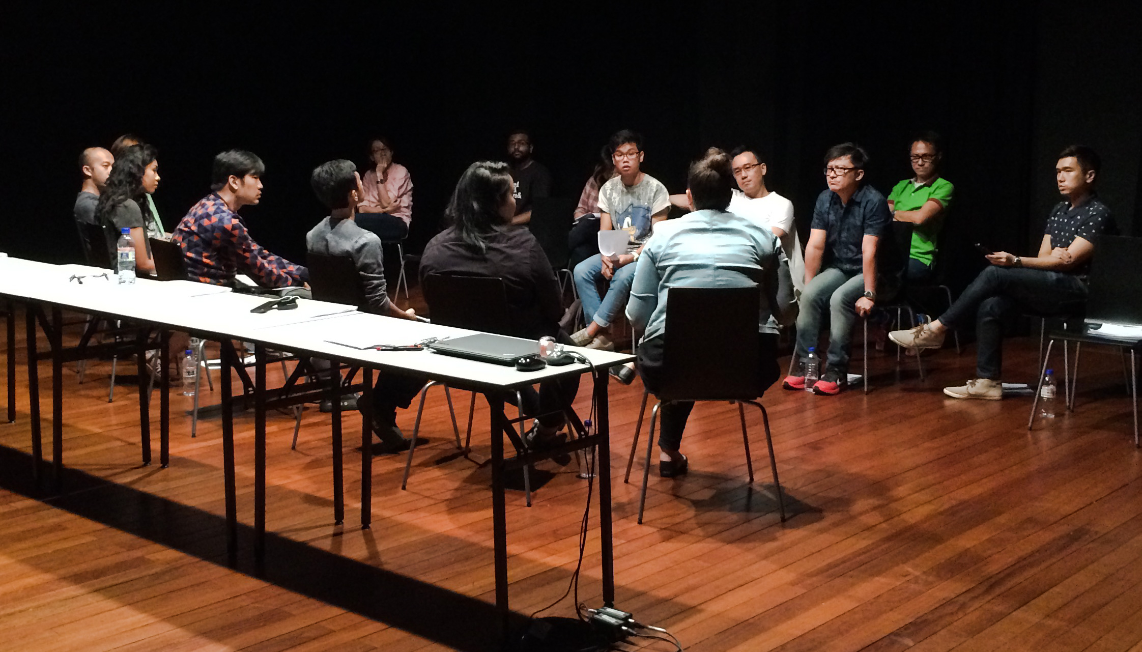 A large group of people seated facing each other, talking.