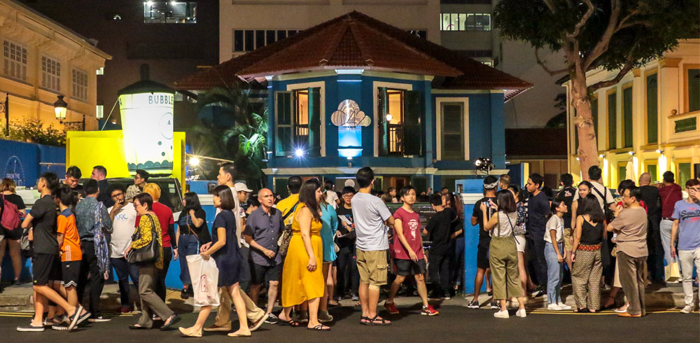 A large crowd of people outside 42 Waterloo Street at night.