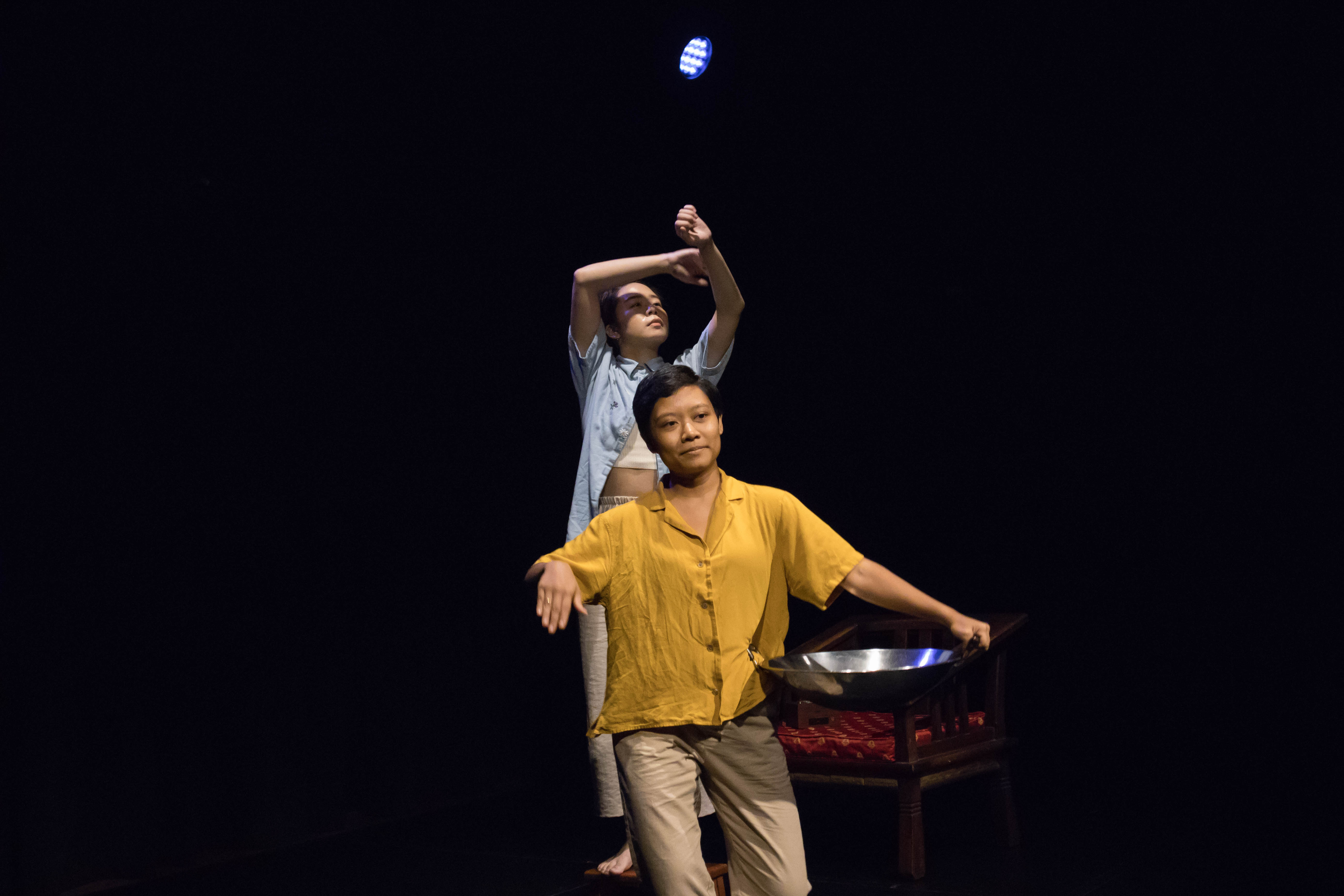 Photograph for The Vault: RE:CALL, with two dancers in a dark setting, wearing light blue and yellow outfits.