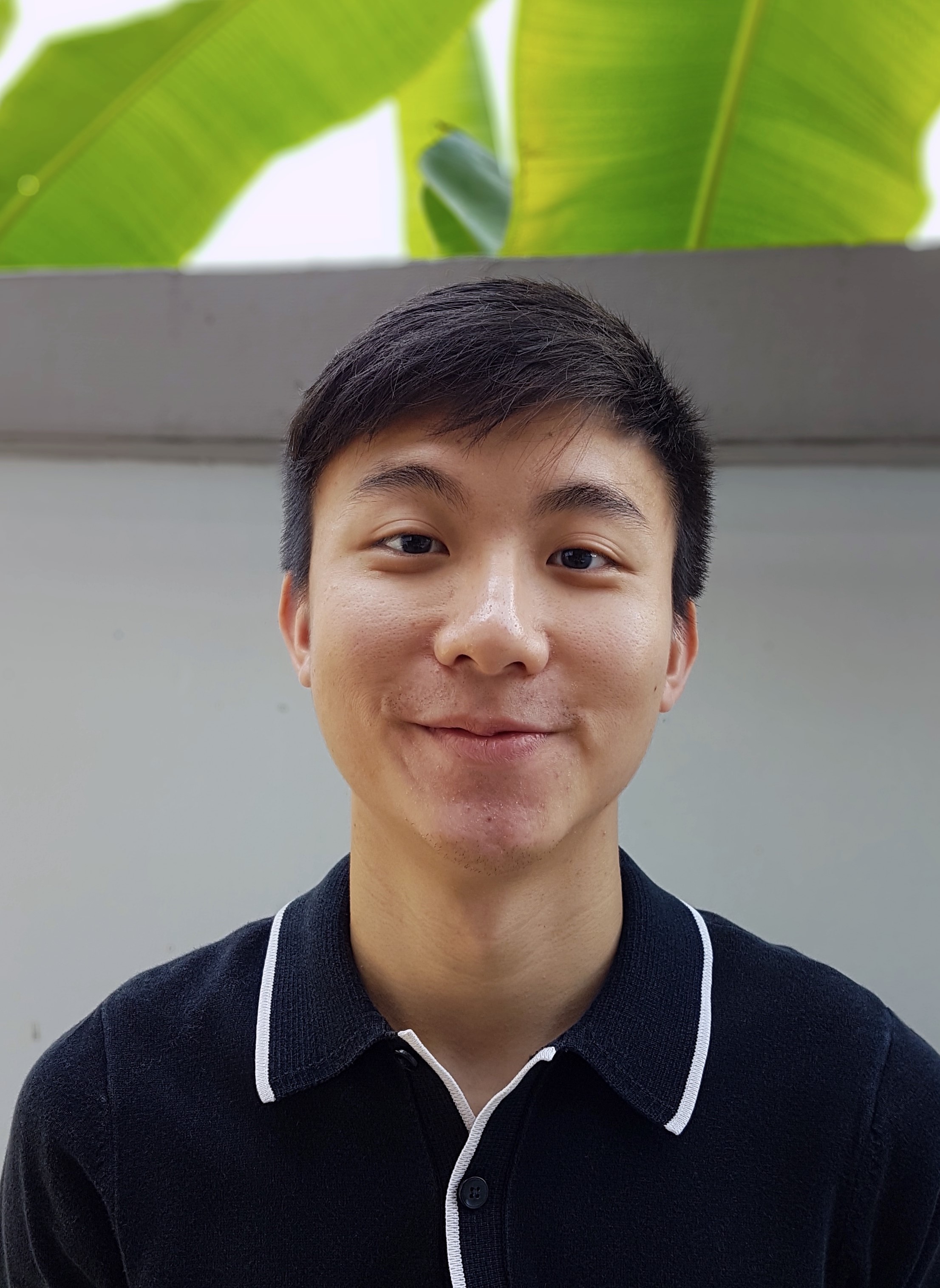 A headshot of Nathaniel Tan in a black shirt, looking into the camera.