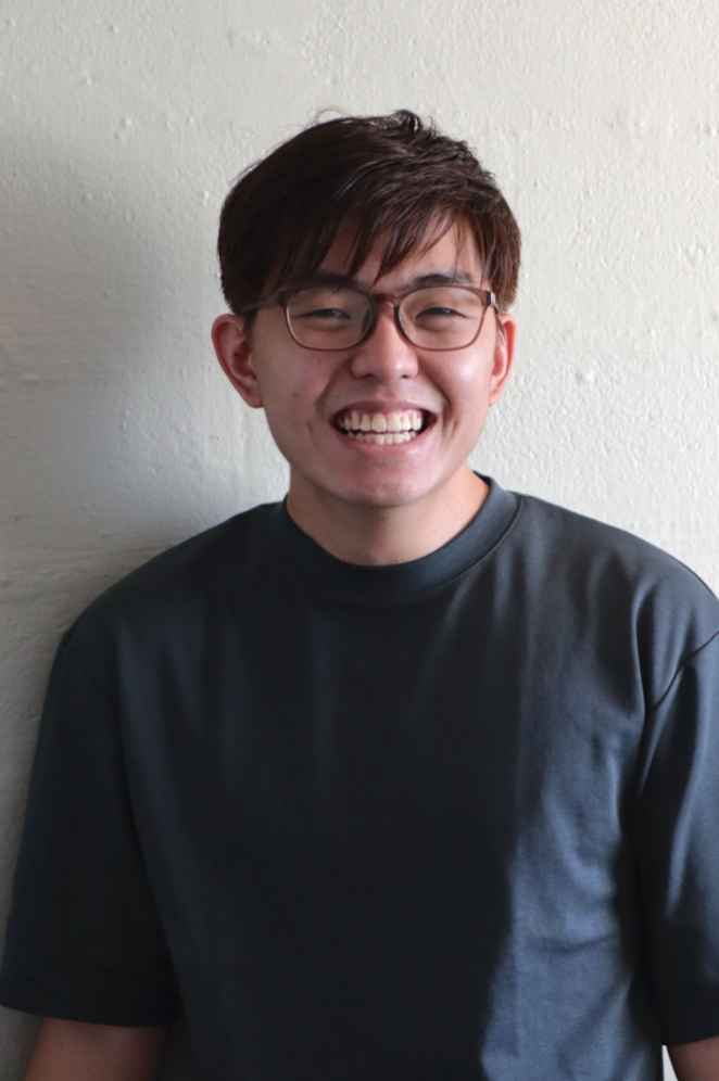 Coloured headshot of a bespectacled man in a navy blue shirt.