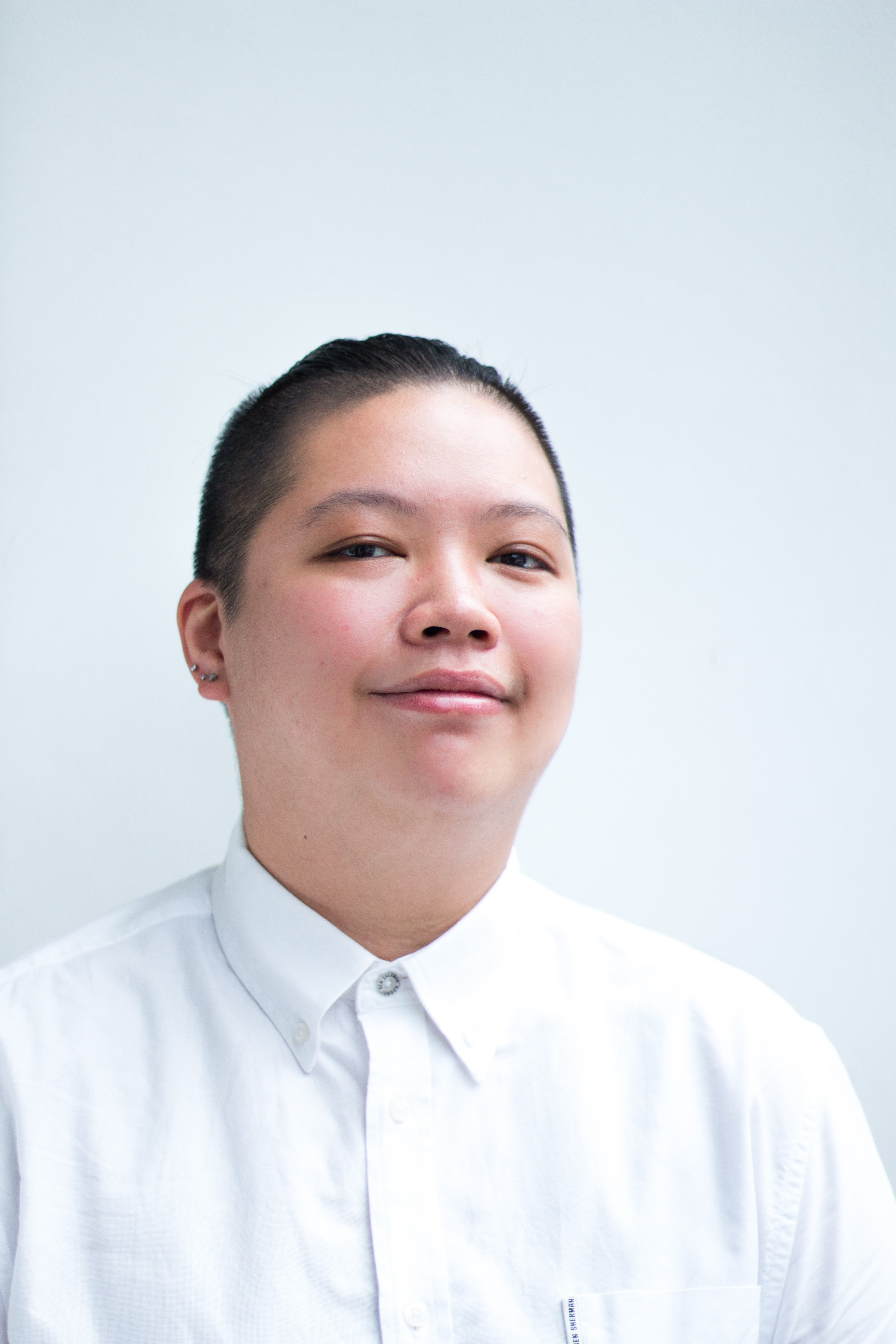 A headshot of Tan Liting in a white shirt, smiling into the camera.