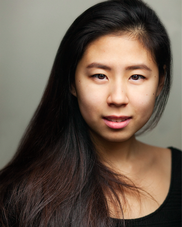 A headshot of Victoria Chen against a grey wall, looking into the camera.