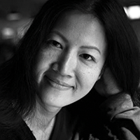 Black and white headshot of Janice Poon, smiling.