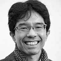 Black and white headshot of Ken Hagiwara in glasses, smiling.