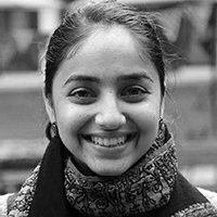 Black and white headshot of Virkein Dhar, smiling.