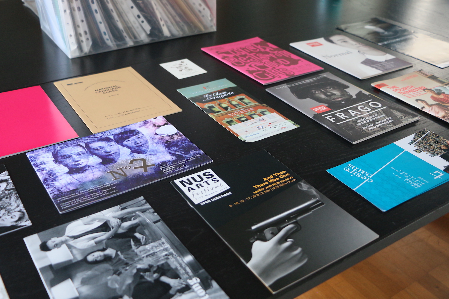 Several assorted programmes neatly arranged on a black table.