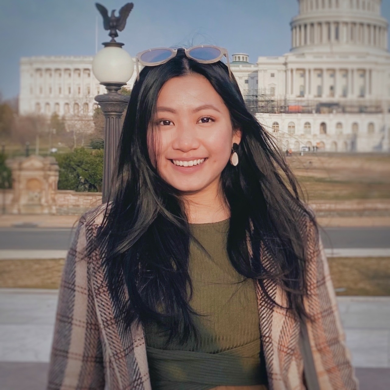 Half-body shot of Ariel Lim outside a historical building, with glasses on top of her head.