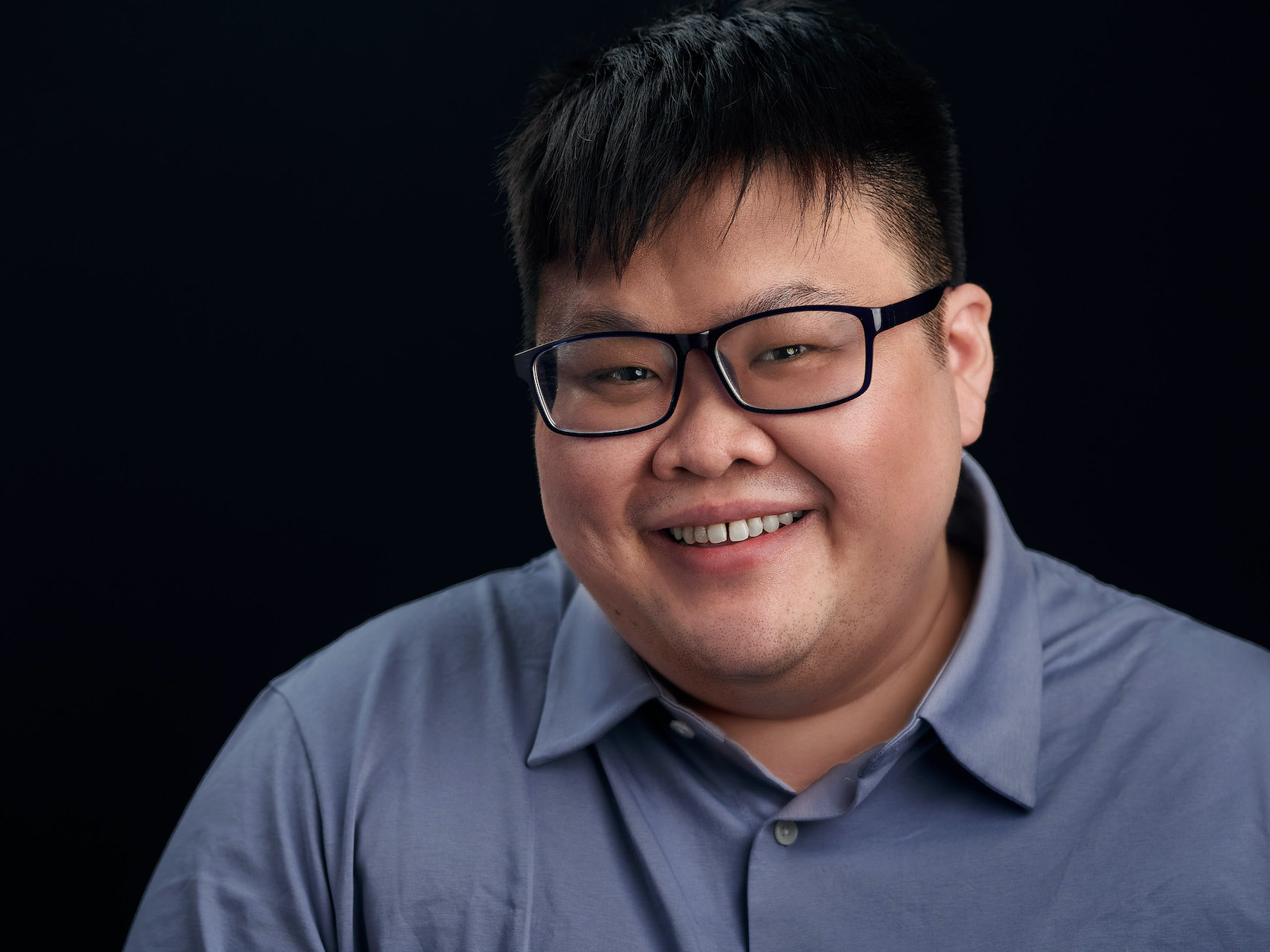 Headshot of Isaac Lim in glasses and a blue collared shirt, smiling.