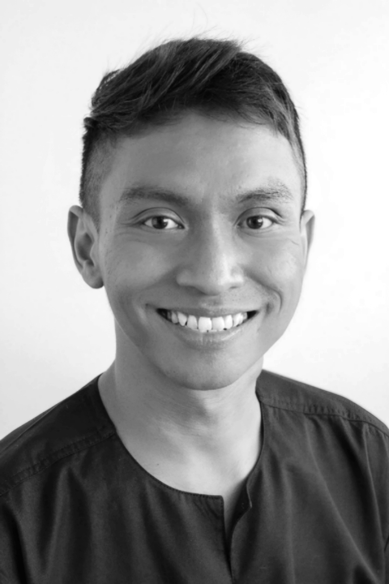 Black and white headshot of Haddad Wan Salleh, smiling wide, wearing a black shirt.