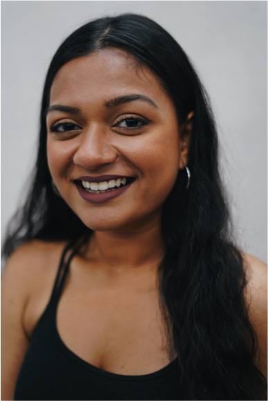 Headshot of Masturah Oli in a black tank top, smiling into the camera.