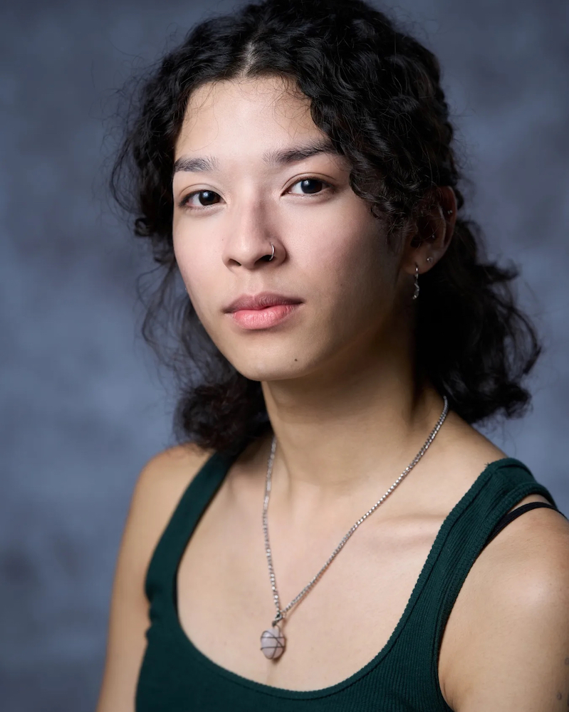 Headshot of Medli Dorothea Loo in a green tank top and necklace, looking into the camera.