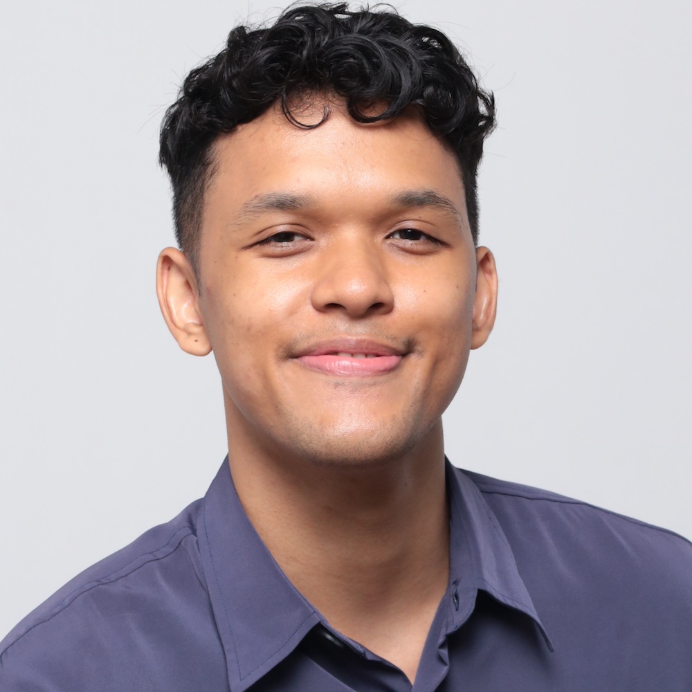 Headshot of Irsyad Dawood in a purple collared shirt, smiling into the camera.