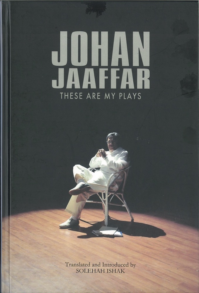 The publication features a male-presenting person in white clothing, seated on a white chair on a stage, under a spotlight.