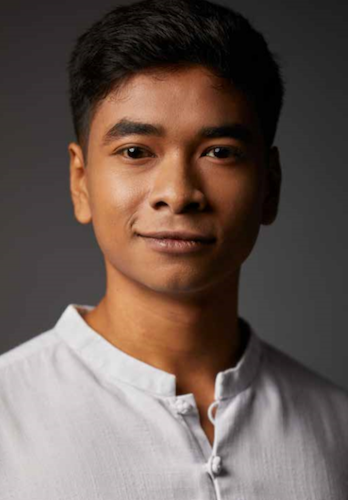 Headshot of Shahid Nasheer in a grey shirt, against a dark grey background.