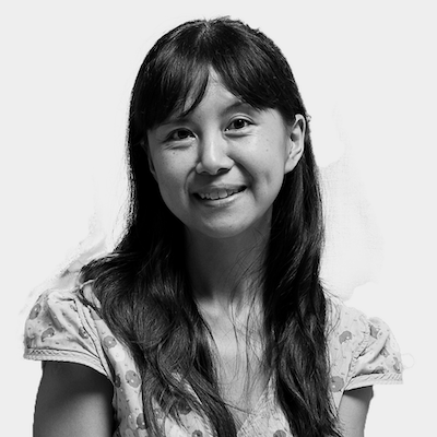 Black and white headshot of a female-presenting person with long hair.