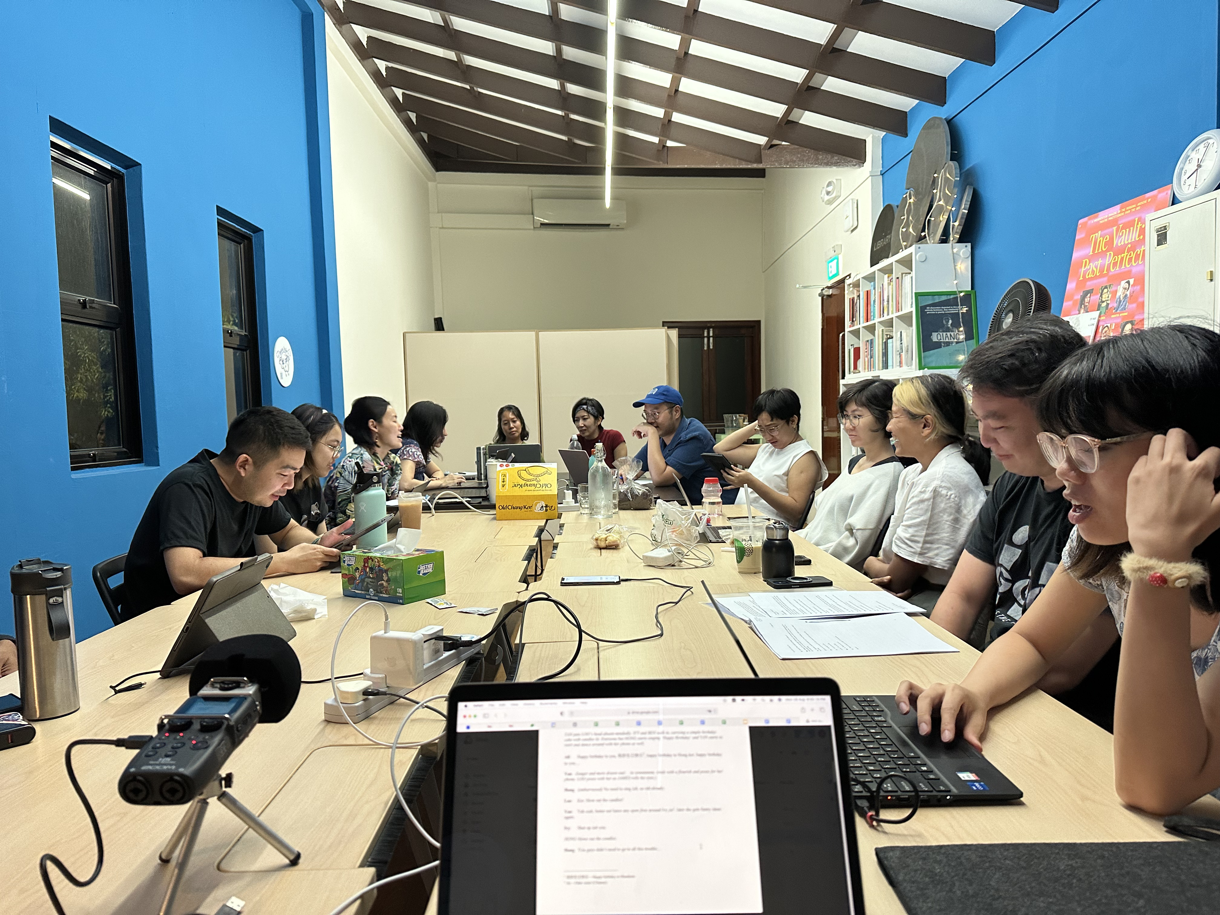 A group of 12 people seen seated around rectangular tables. 