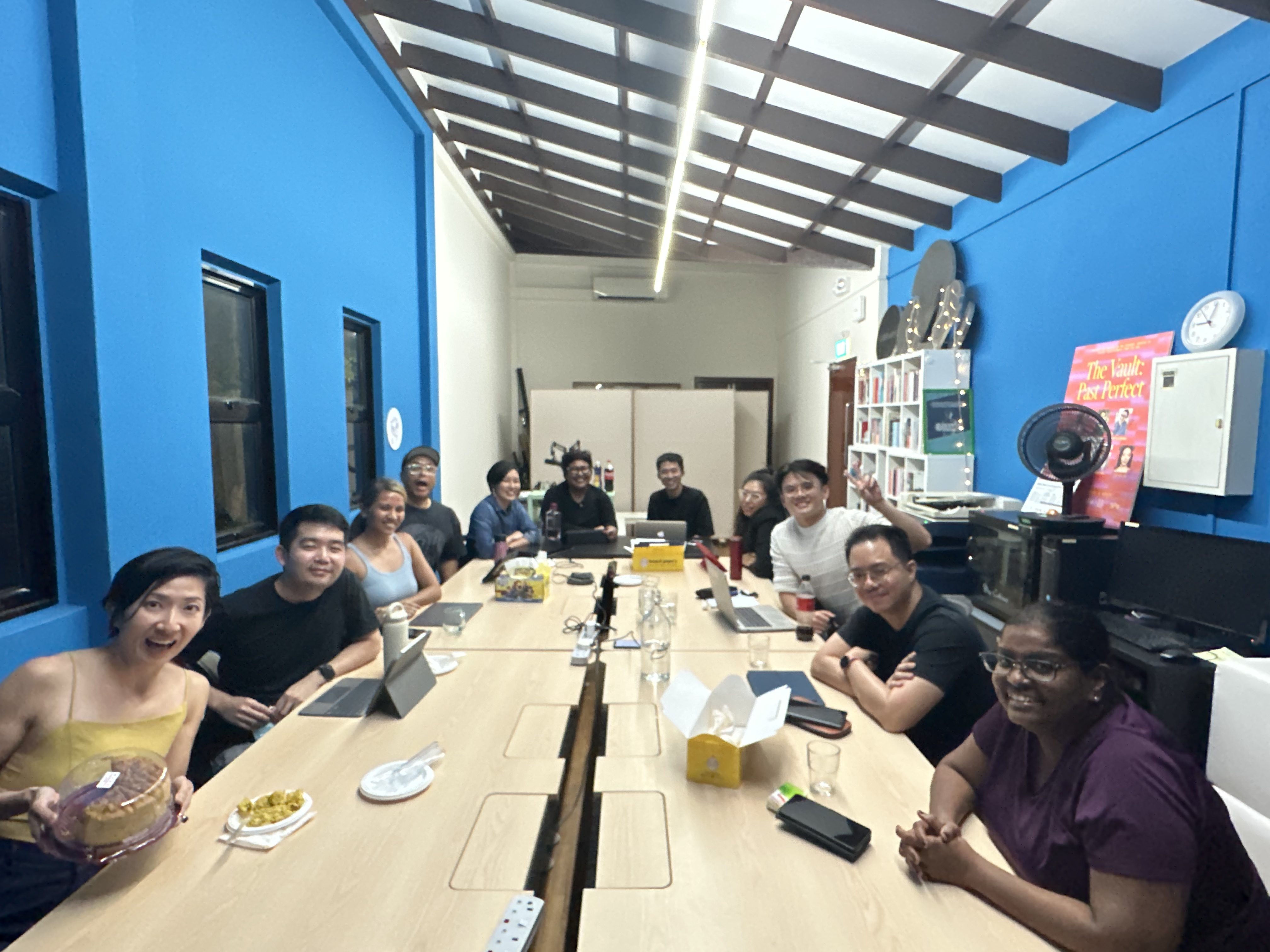 A group photo with 11 people seated around a table.